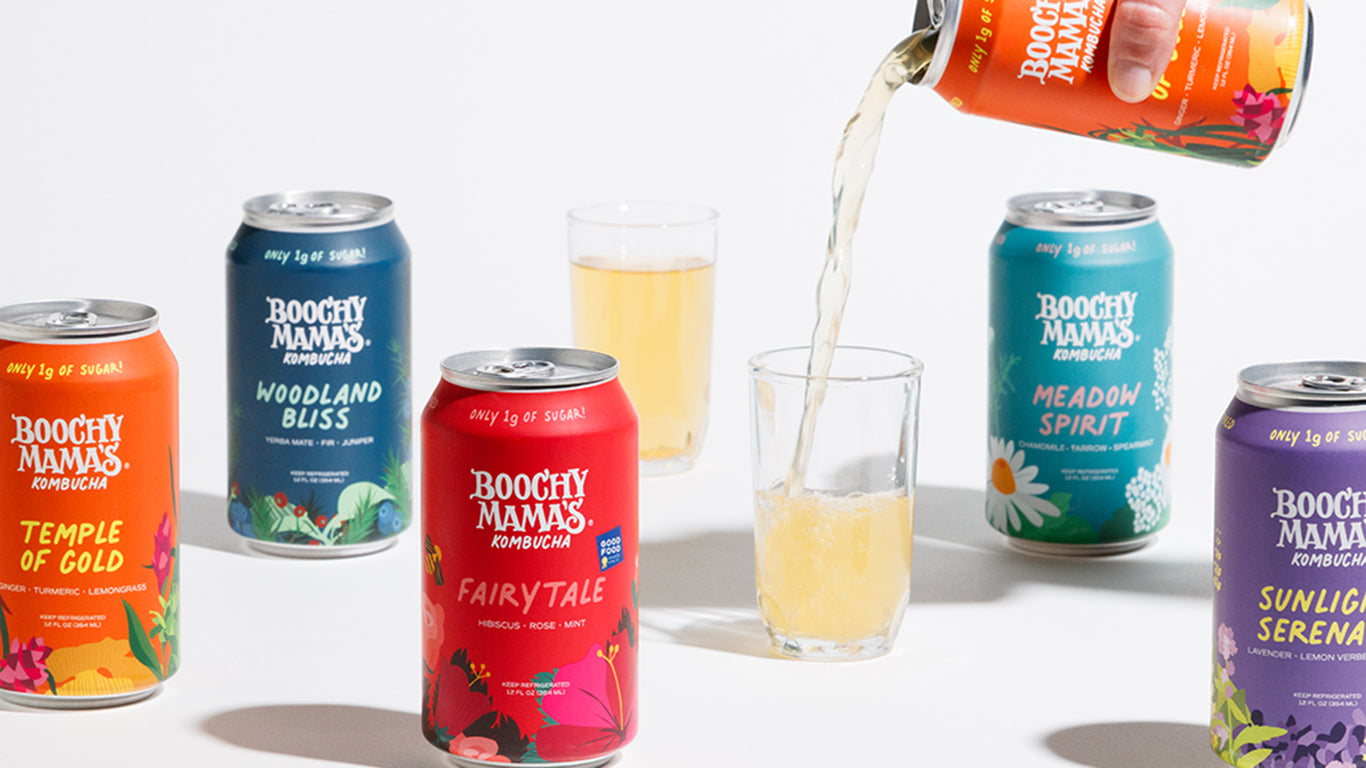 Assorted cans of Boochy Mama's Kombucha beverages with glasses on a white background with one can being poured.